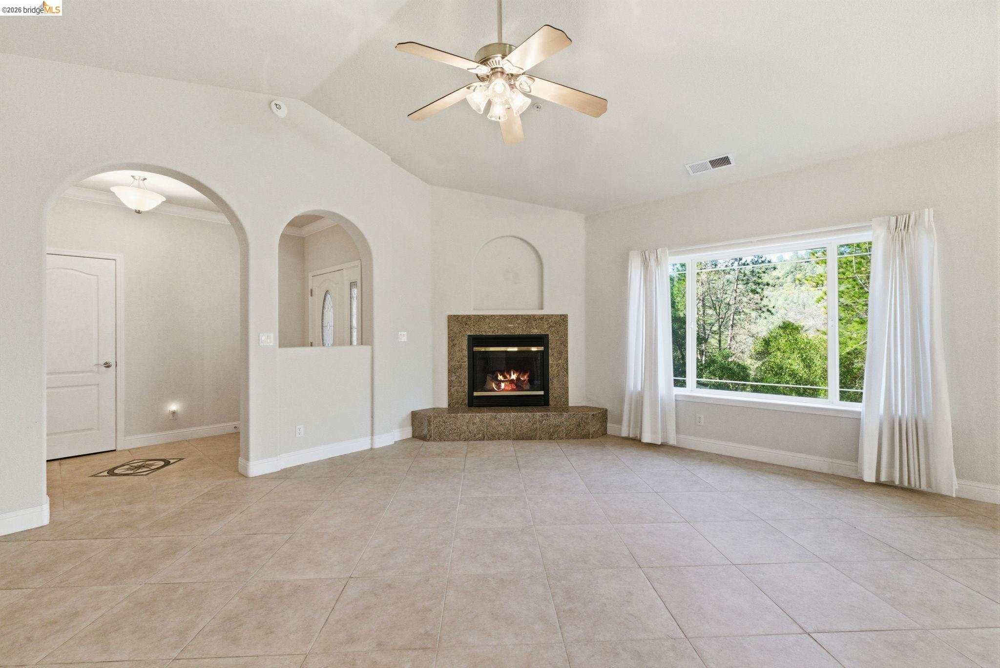 20245 Tuolumne Road North Tuolumne, CA 95379 - Photo 9 of 43 a view of an empty room with a fireplace and a window
