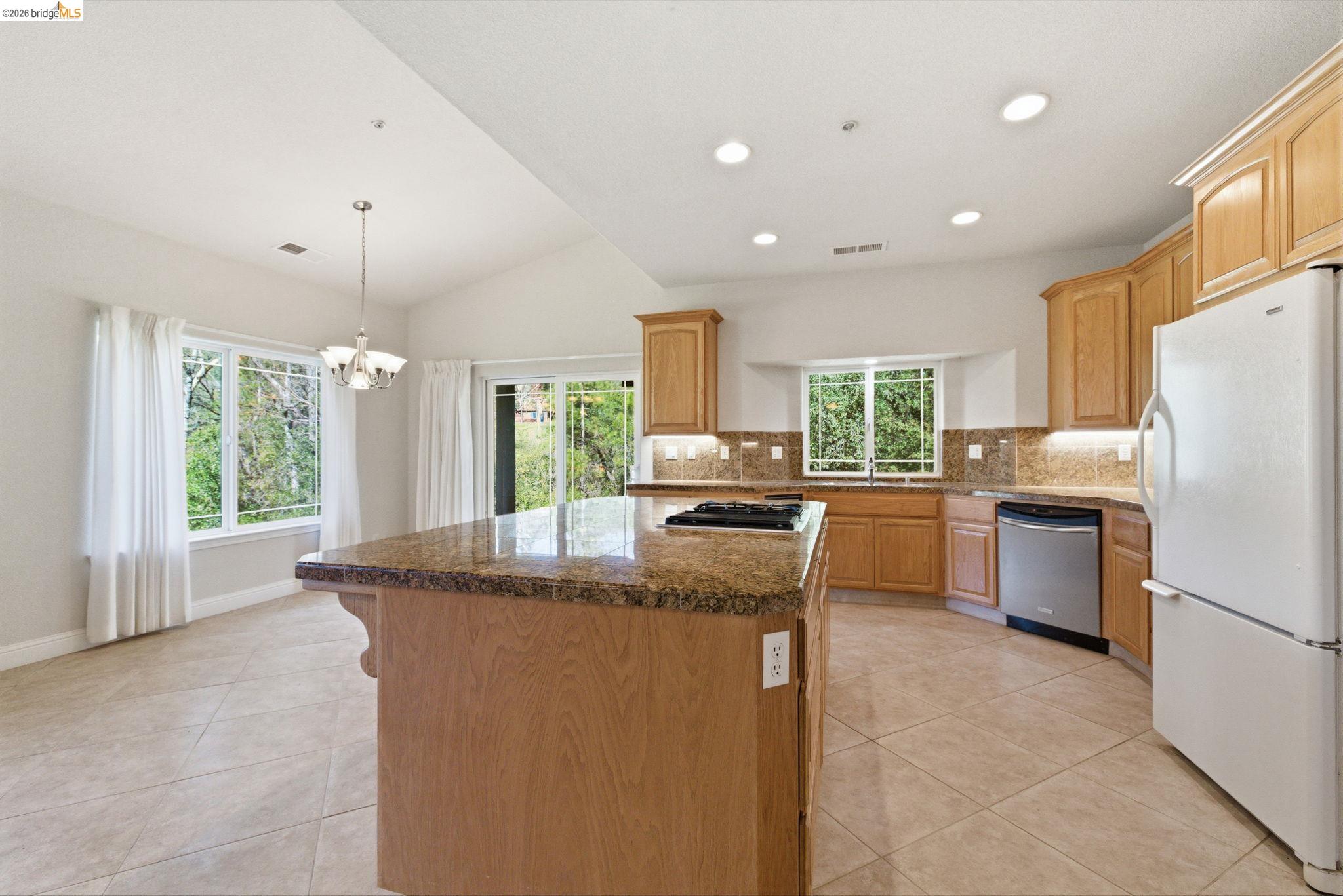 20245 Tuolumne Road North Tuolumne, CA 95379 - Photo 10 of 43 a kitchen with refrigerator a sink and chairs
