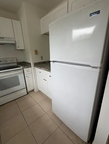 a kitchen with a refrigerator and a stove top oven