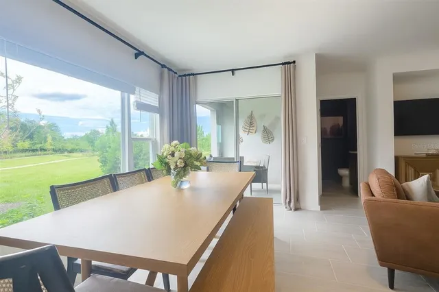 a dining room with furniture and a large window