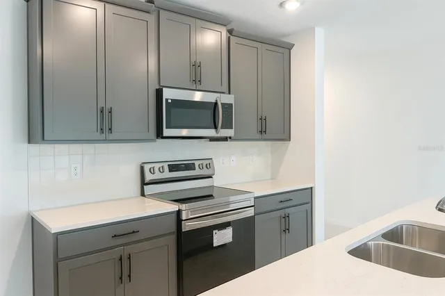 a view of kitchen with stainless steel appliances a refrigerator and a stove top oven
