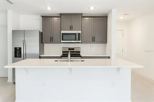 a view of kitchen with stainless steel appliances a refrigerator and a stove top oven