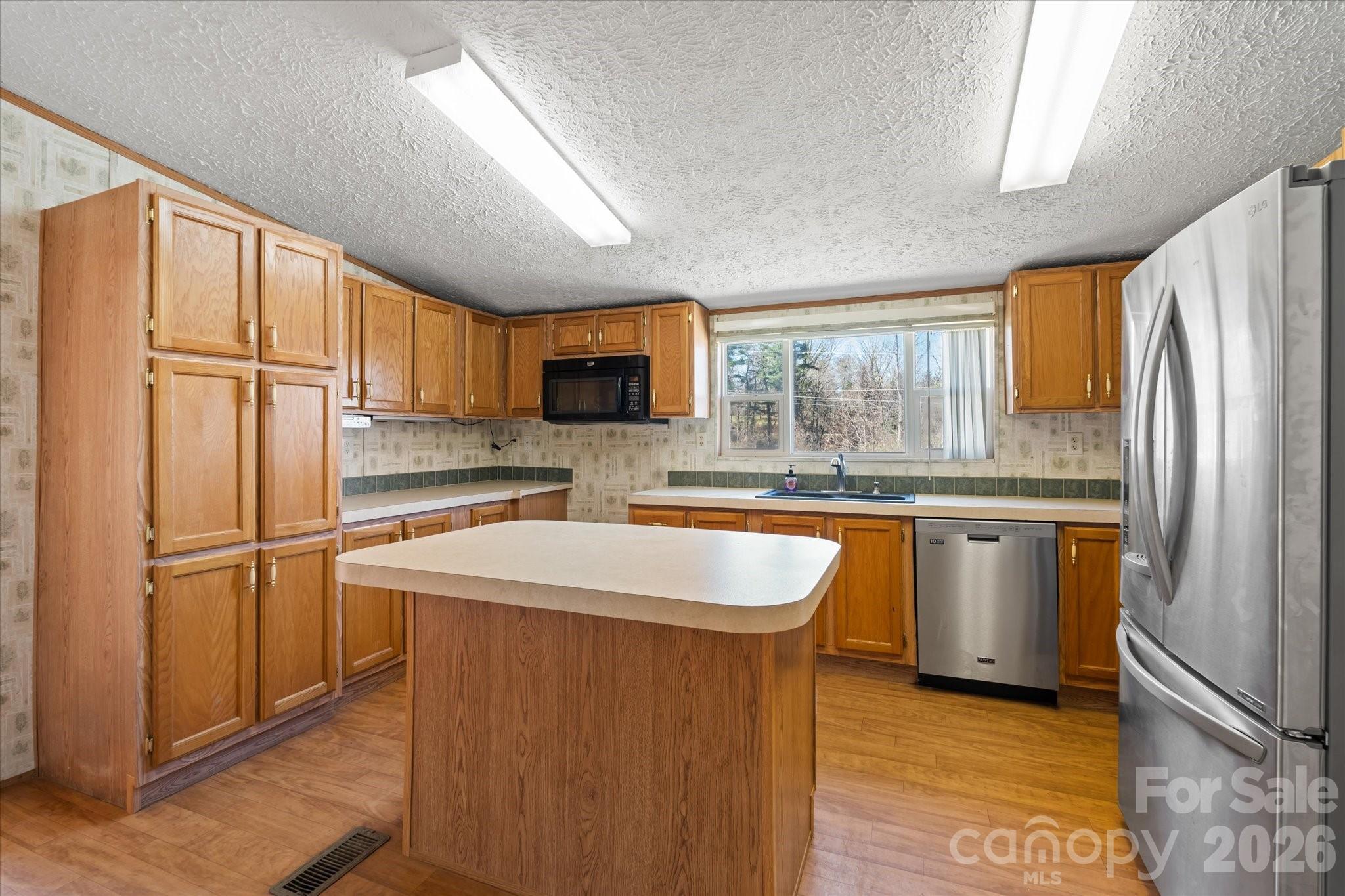 18 Ford Valley Road Weaverville, NC 28787 - Photo 12 of 37 a kitchen with stainless steel appliances granite countertop a refrigerator a sink dishwasher a stove top oven a refrigerator and white cabinets with wooden floor