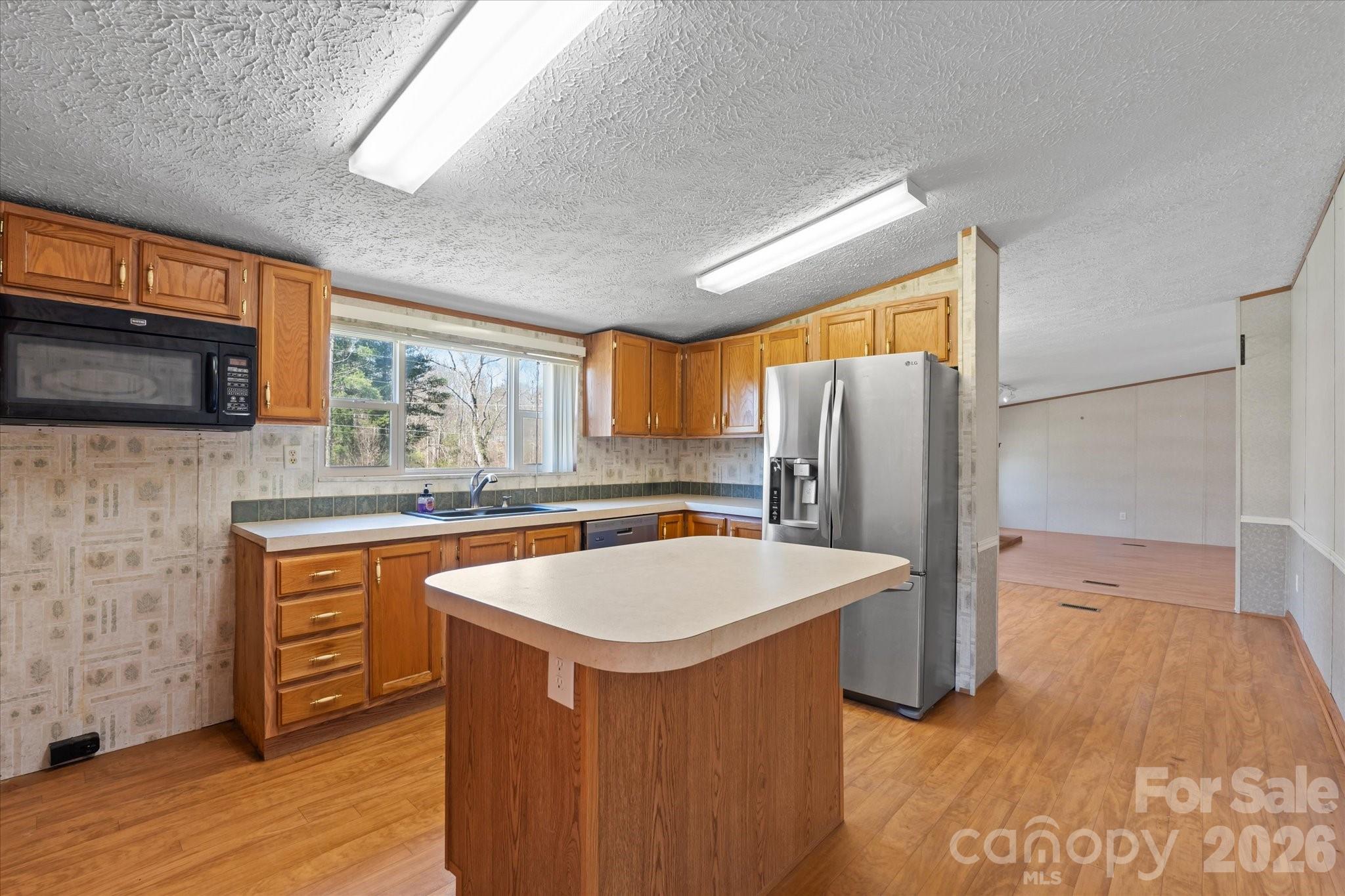 18 Ford Valley Road Weaverville, NC 28787 - Photo 13 of 37 a kitchen with stainless steel appliances granite countertop a sink a stove a refrigerator a washer dryer and white cabinets