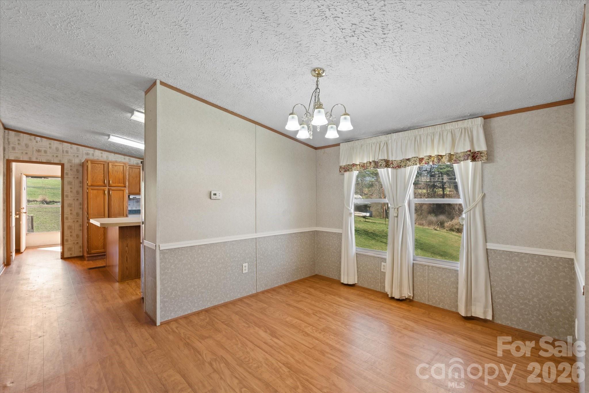 18 Ford Valley Road Weaverville, NC 28787 - Photo 9 of 37 an empty room with wooden floor chandelier and windows
