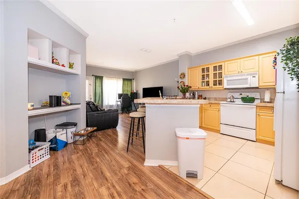 a living room with a sink a kitchen counter top space and a stove top oven