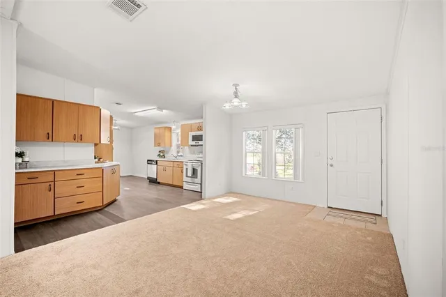 a kitchen with stainless steel appliances a white stove top oven cabinets a sink and a window