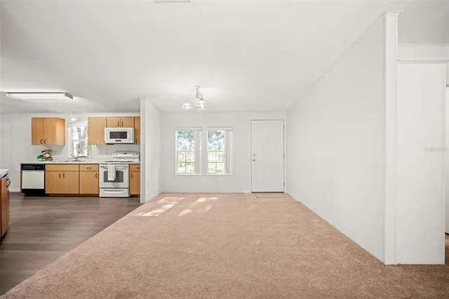 an empty room with a ceiling fan and a window