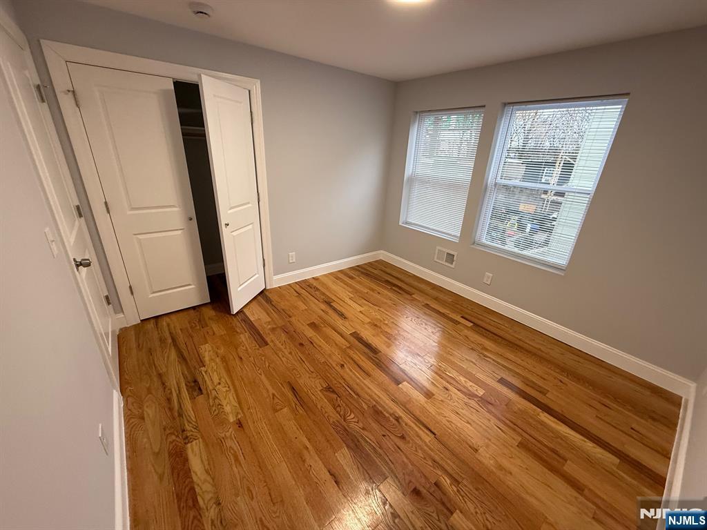 82 South Devine Street Newark, NJ 07106 - Photo 2 of 4 a view of an empty room with wooden floor and a window