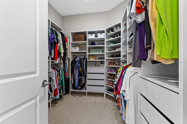 a view of walk in closet with clothes and shoes
