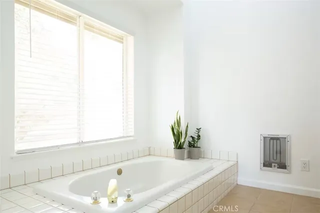 a white bath tub sitting in a bathroom next to a window