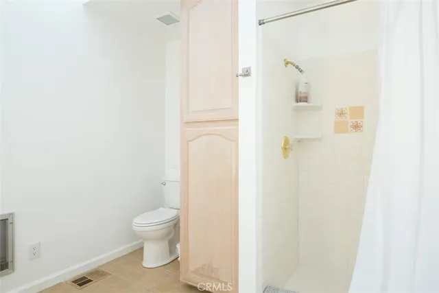 a bathroom with a toilet and a shower