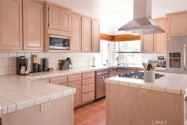 a kitchen with cabinets appliances a sink and a window