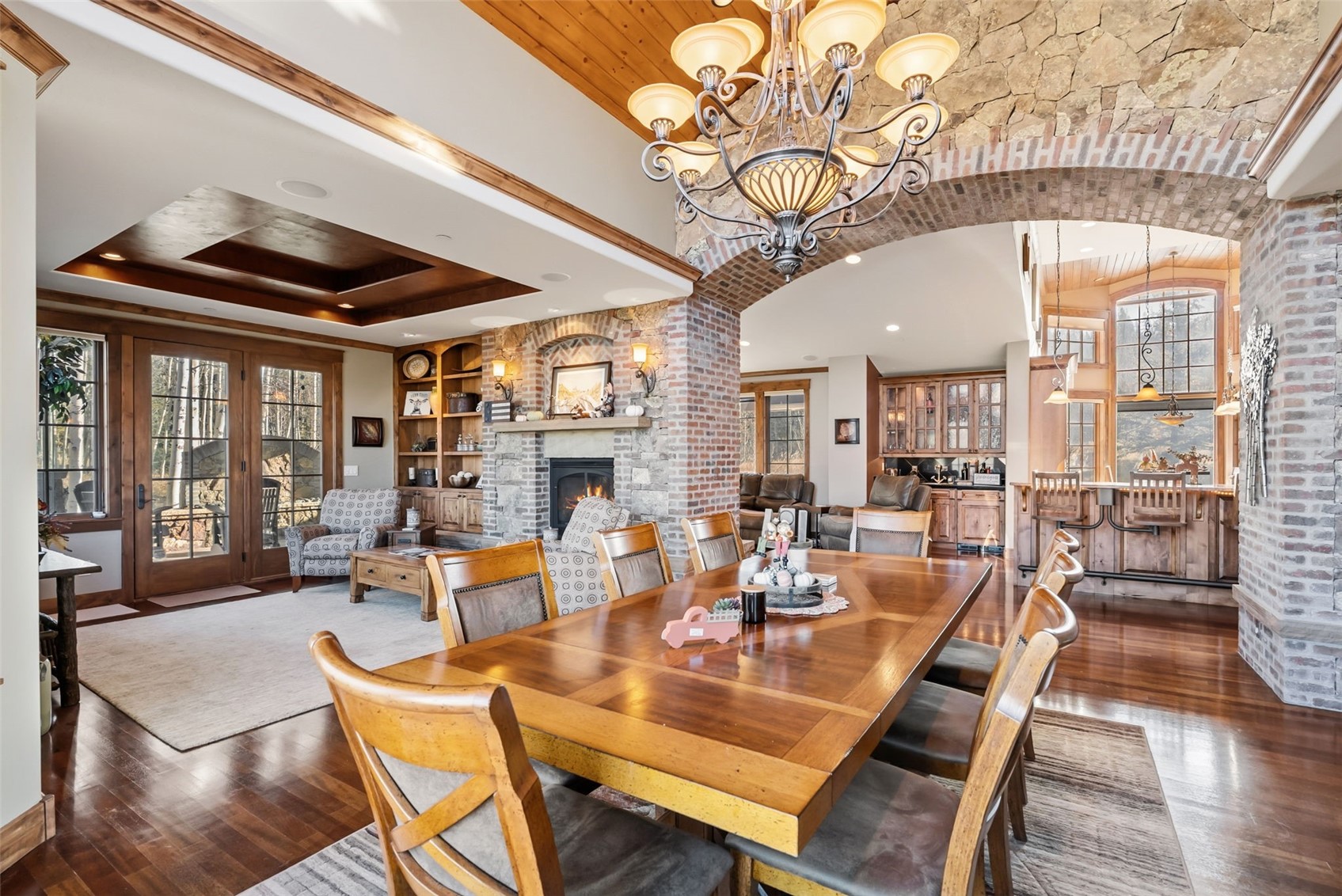 2140 Hunter's Knob Road Silverthorne, CO 80498 - Photo 5 of 46 Dining room featuring healthy amount of natural light, a fireplace, dark wood-style flooring, and a chandelier