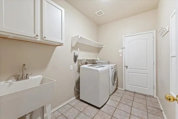 a utility room with cabinets washer and dryer