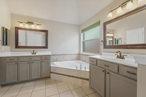 a bathroom with a tub sink and mirror