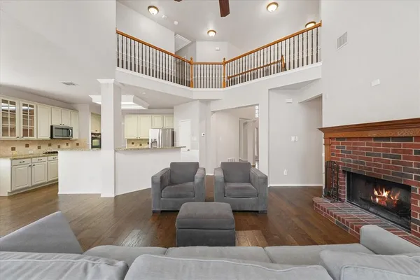 a living room with furniture a fireplace and kitchen view
