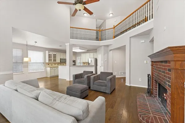 a living room with furniture a fireplace and wooden floor