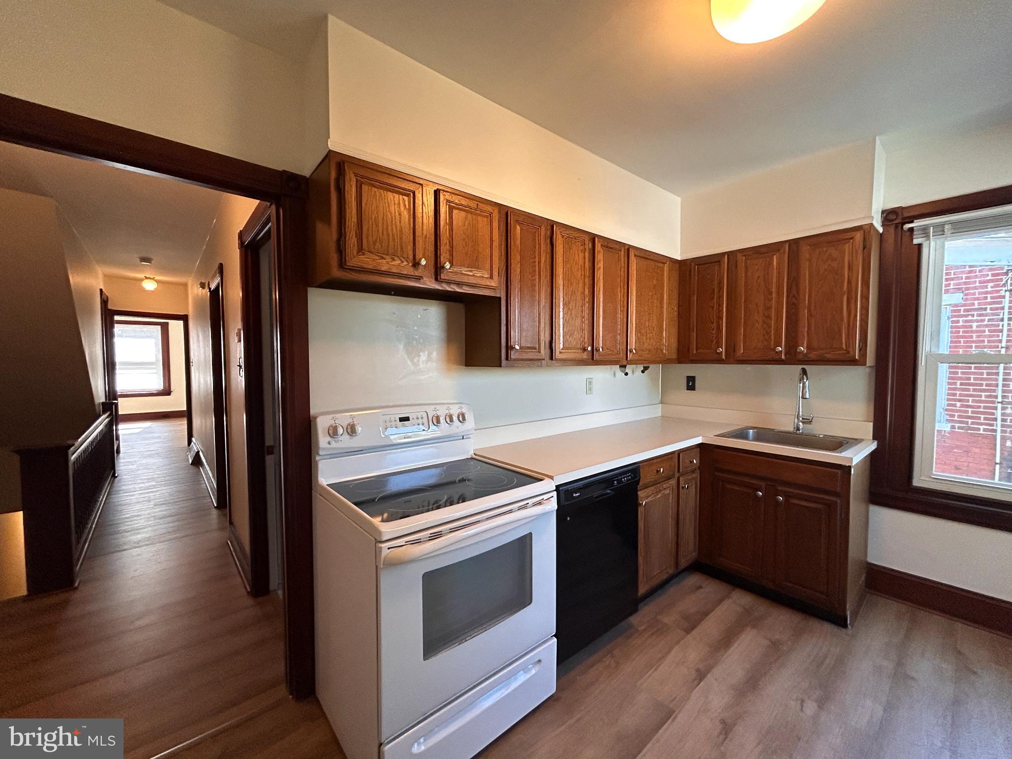 113 Dean Street, Unit 2 West Chester, PA 19382 - Photo 5 of 28 a kitchen with stainless steel appliances wooden floors and wooden cabinets