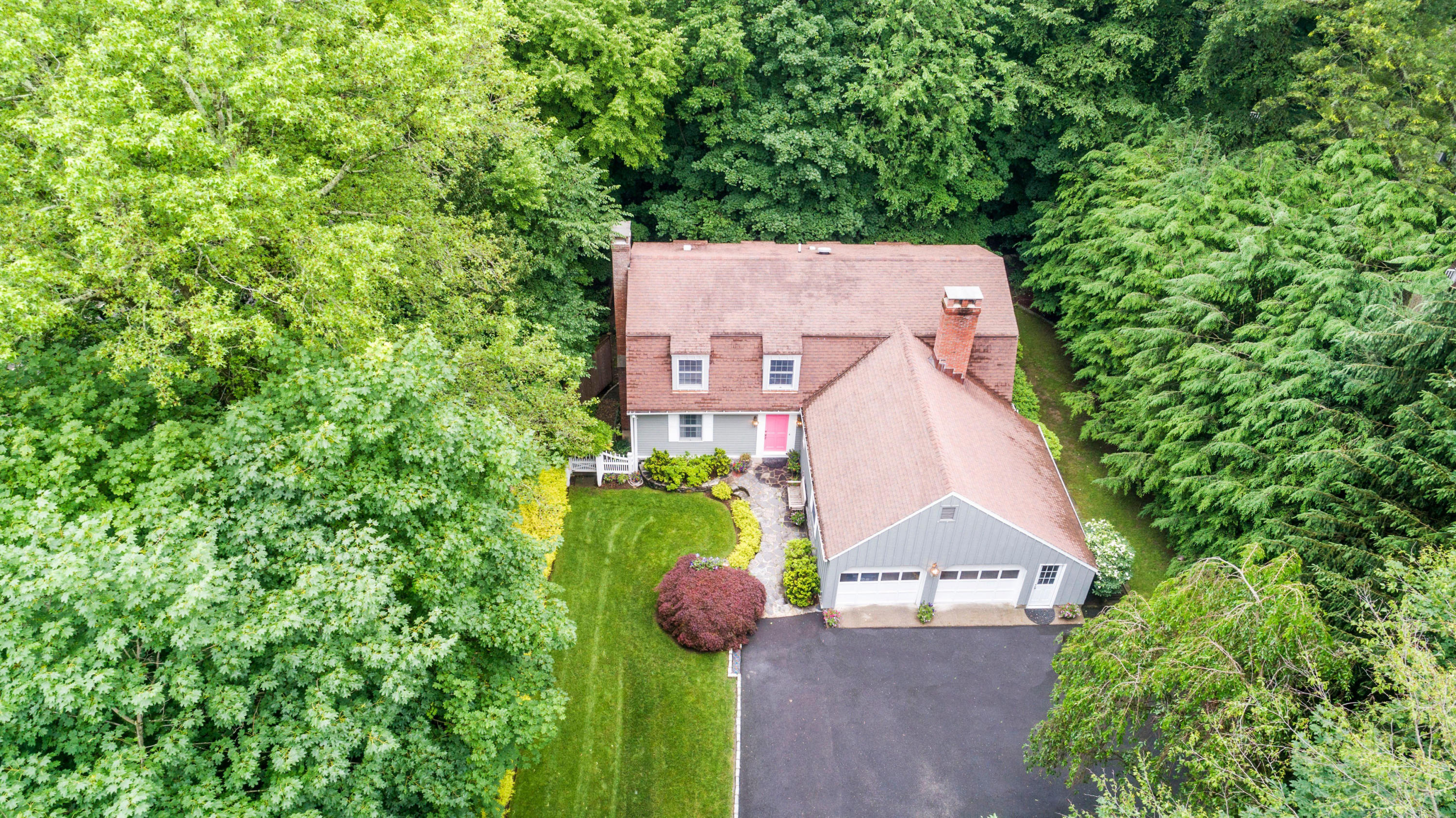 an aerial view of a house with a yard and a large tree