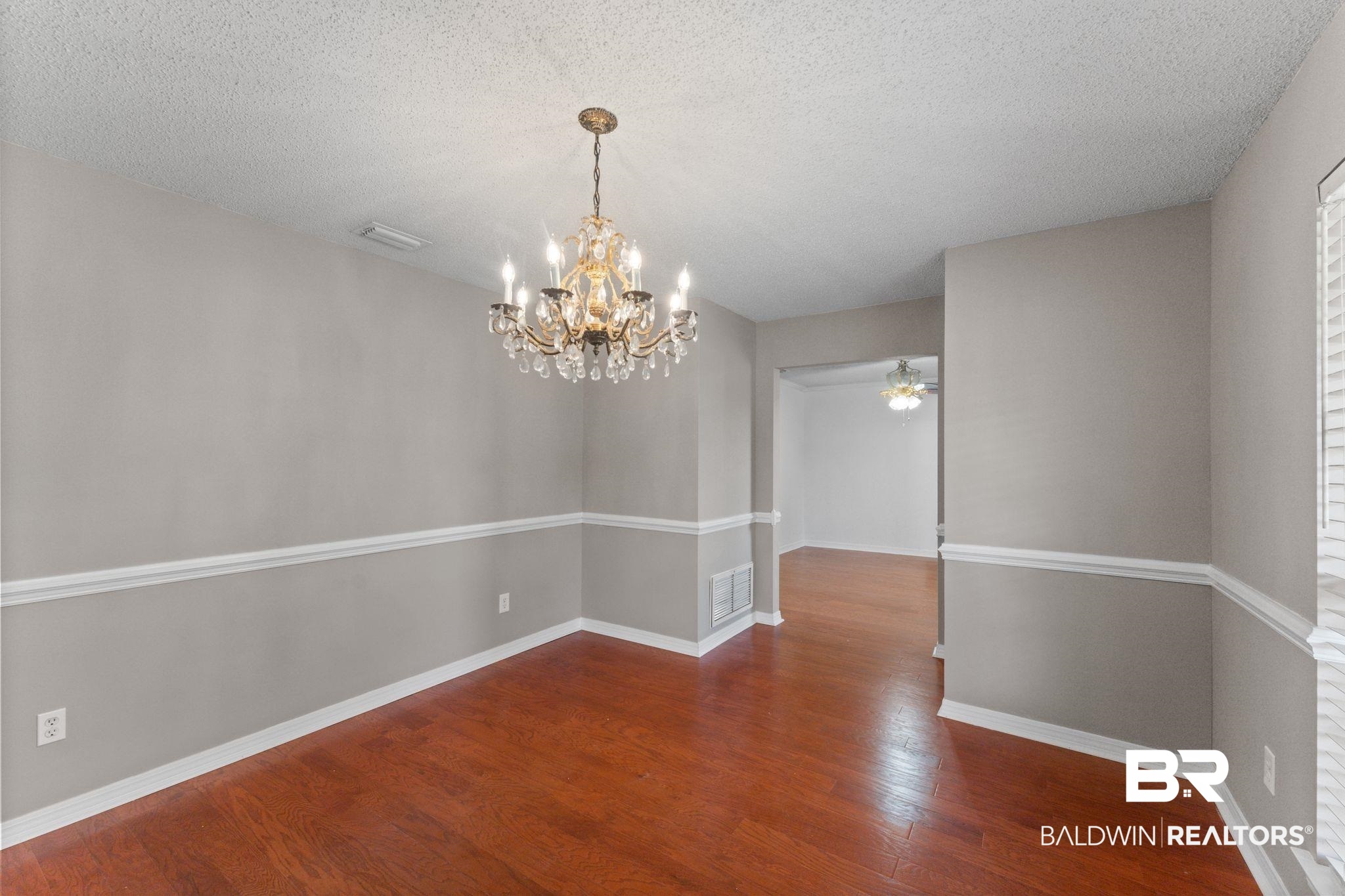 888 Mobile Cut-Off Road St. Stephens, AL 36569 - Photo 11 of 54 Unfurnished dining area with dark wood finished floors, a textured ceiling, a chandelier, and a ceiling fan
