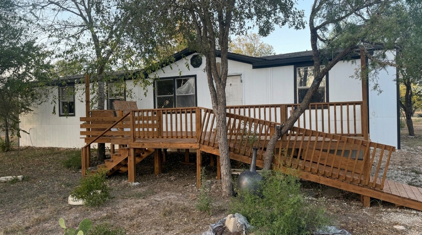 1230 Black Ankle Road Lockhart, TX 78644 - Photo 1 of 1 Mature trees shade a spacious wooden deck and ramp leading to the front entry.