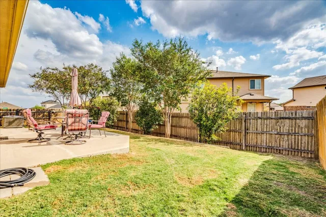 a backyard of a house with table and chairs