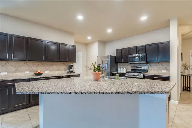a kitchen with sink a refrigerator and cabinets