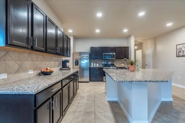 a kitchen with granite countertop stainless steel appliances and a sink