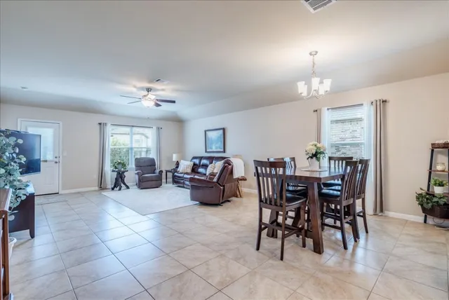a living room with furniture a chandelier and a dining table