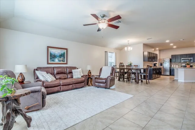 a living room with furniture and a dining table with kitchen view