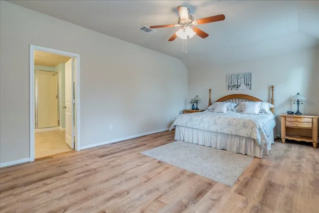 a bedroom with a bed and wooden floor