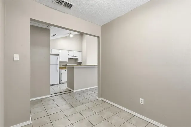 a view of a kitchen with white cabinets and wooden floor