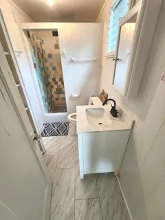a bathroom with a sink and mirror with bathtub