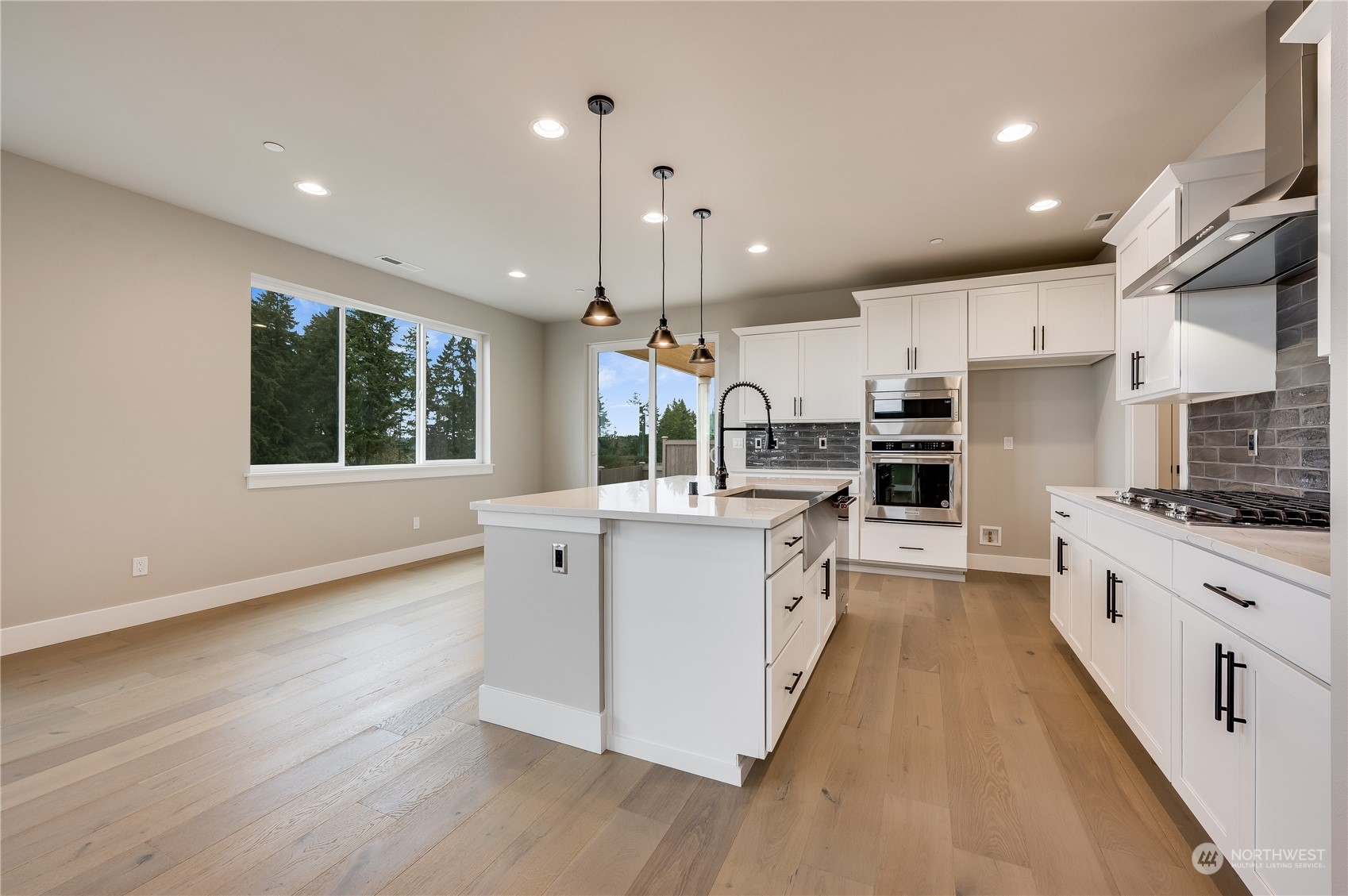 24326 43rd Drive Southeast Bothell, WA 98021 - Photo 7 of 35 a large kitchen with stainless steel appliances kitchen island granite countertop a stove a sink a refrigerator and a wooden floors