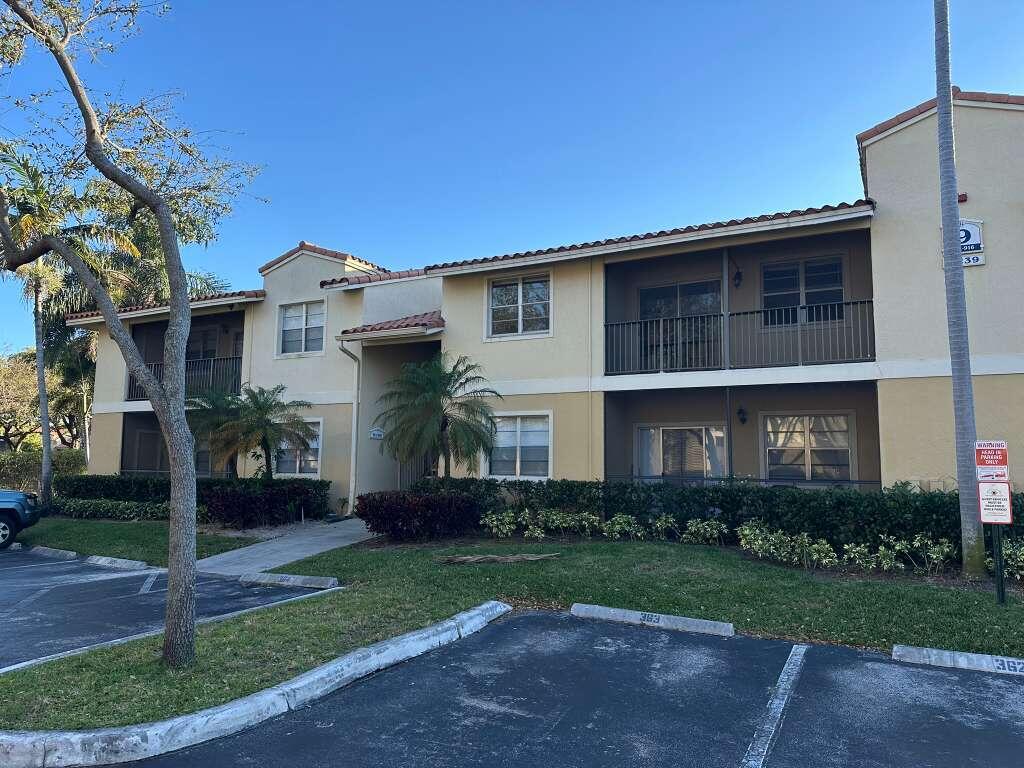 1239 Southwest 46th Avenue, Unit 906 Pompano Beach, FL 33069 - Photo 17 of 23 a front view of a house with a garden and plants