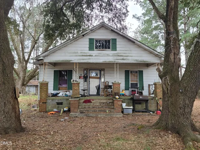 a view of a house with a yard and sitting area