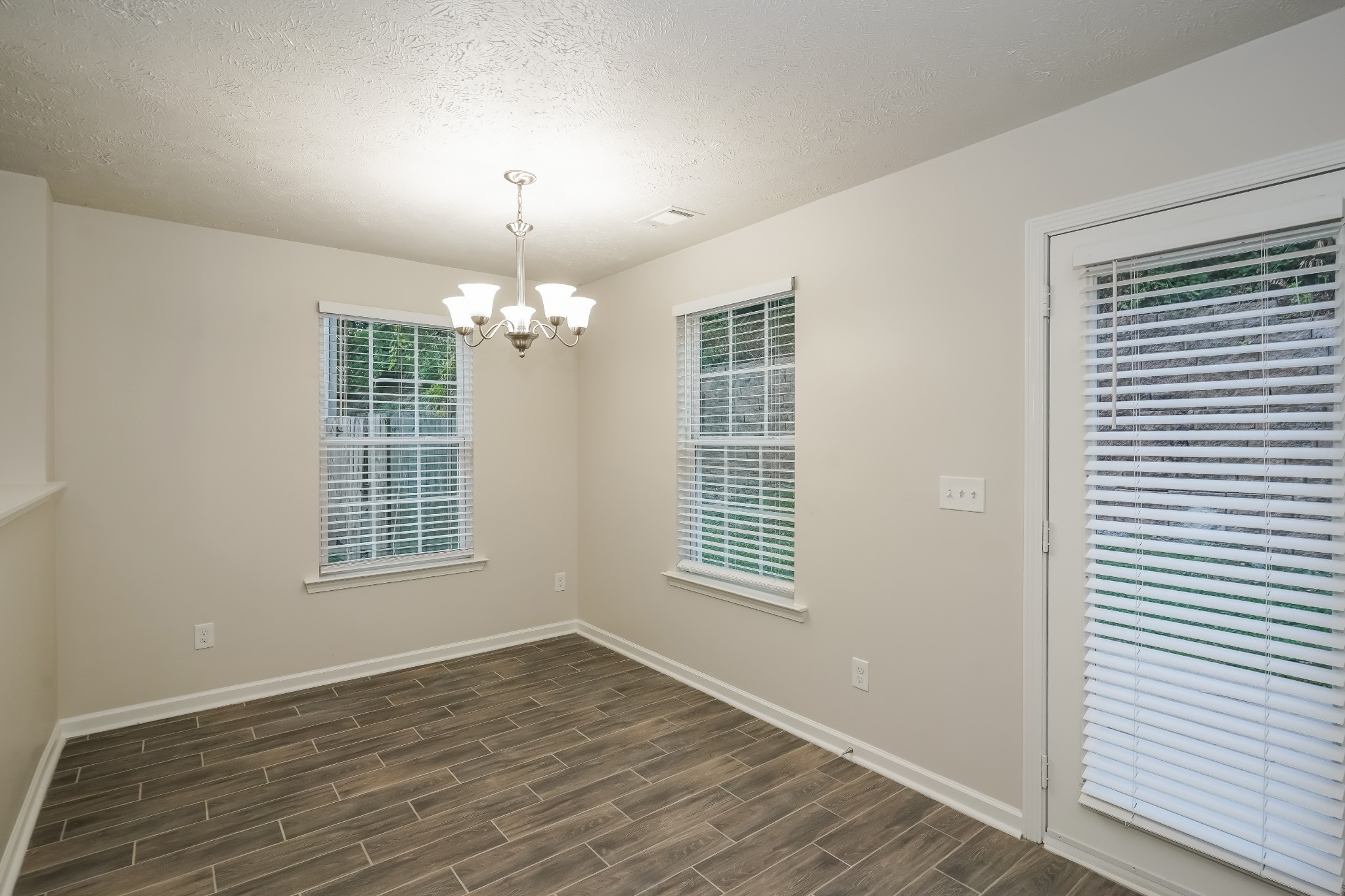 2562 Willow Branch Drive Nashville, TN 37217 - Photo 4 of 17 an empty room with wooden floor chandelier and windows