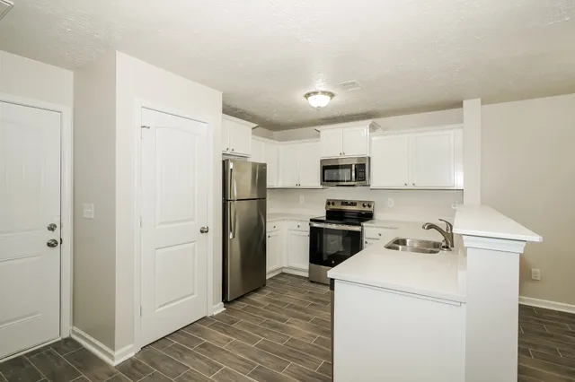 a kitchen with stainless steel appliances a refrigerator a stove a microwave and cabinets