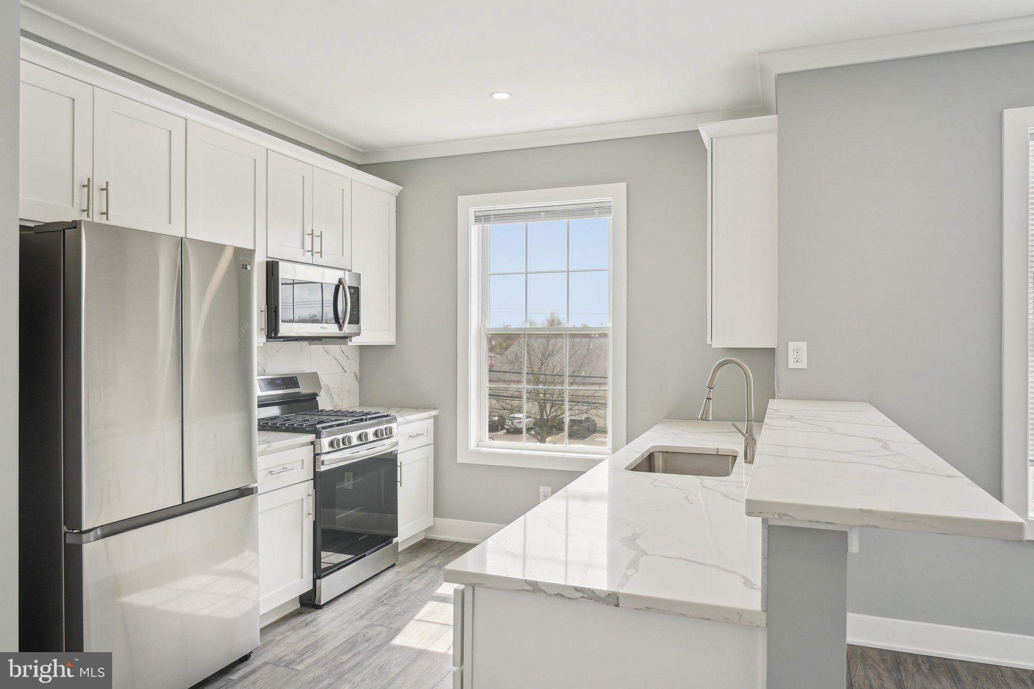 2421 Bristol Road, Unit 2B310 Warrington, PA 18976 - Photo 18 of 50 a kitchen with stainless steel appliances a refrigerator stove and sink