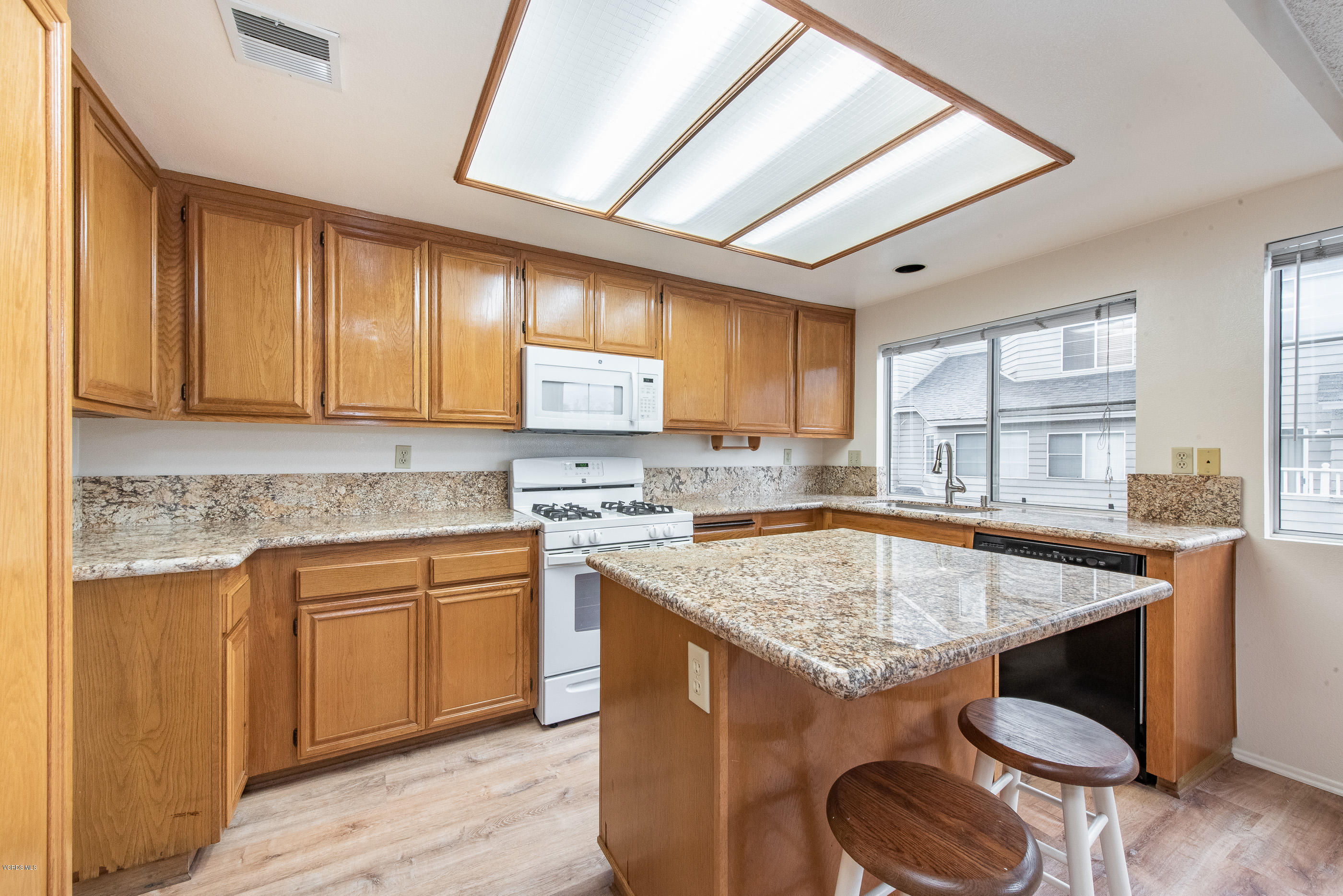 4975 Telephone Road Ventura, CA 93003 - Photo 11 of 31 a kitchen with a stove sink cabinets and wooden floor