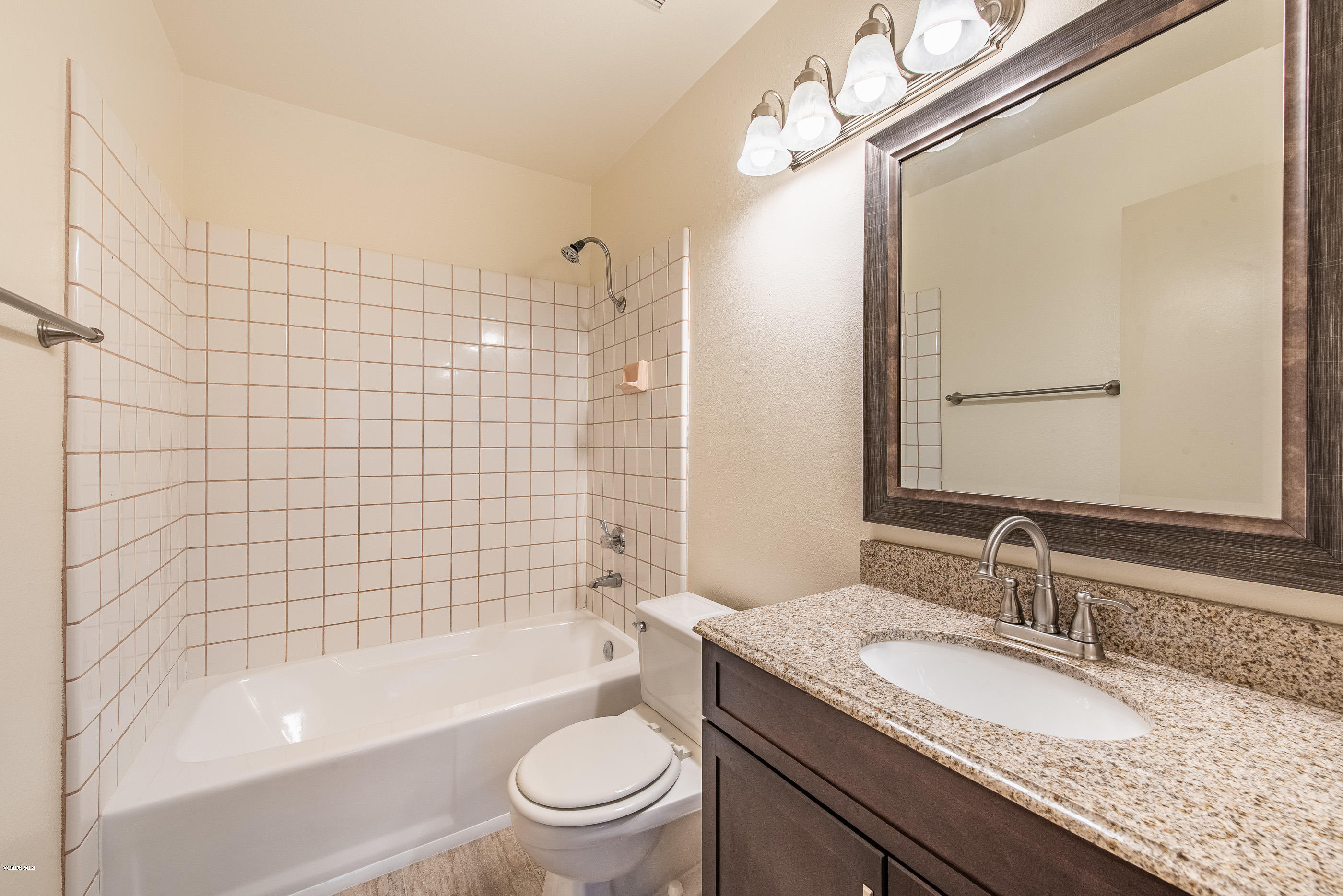 4975 Telephone Road Ventura, CA 93003 - Photo 24 of 31 a bathroom with a granite countertop bathtub shower sink vanity mirror and toilet