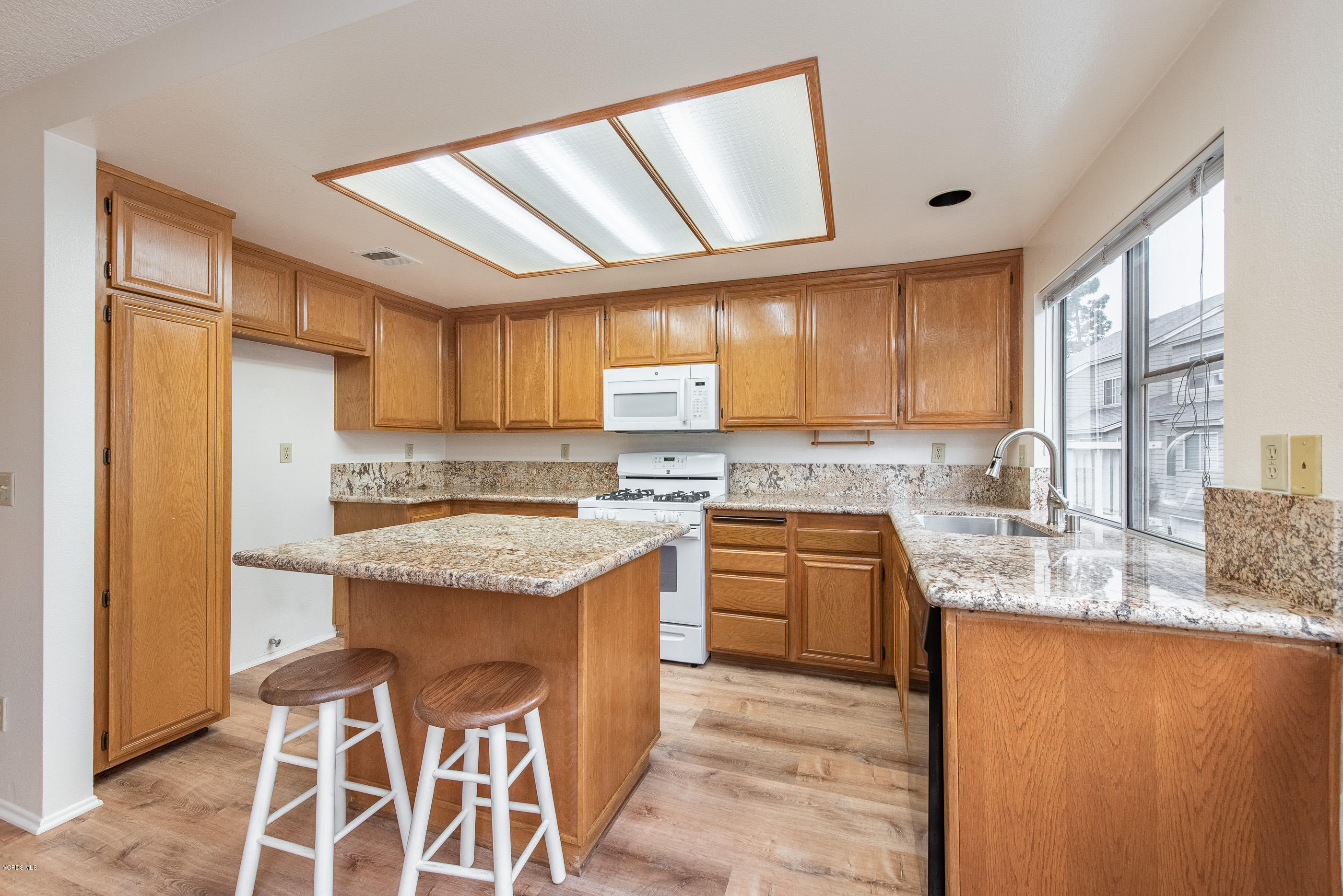 4975 Telephone Road Ventura, CA 93003 - Photo 10 of 31 a kitchen with stainless steel appliances granite countertop a sink stove and refrigerator