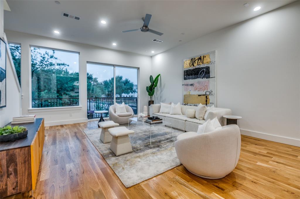 4133 North Reserve Lane Addison, TX 75001 - Photo 2 of 20 a living room with fireplace furniture and a wooden floor