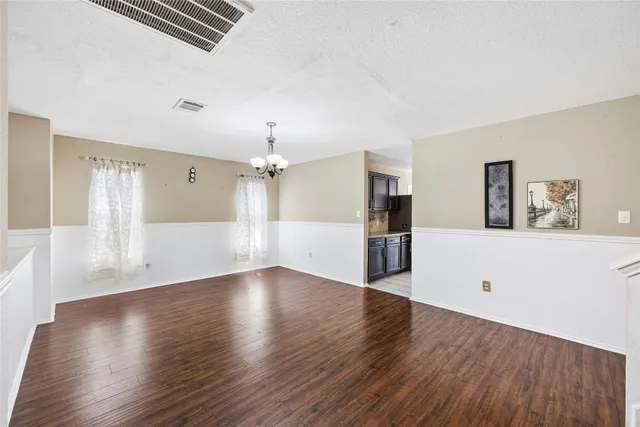 a view of a big room with wooden floor and windows