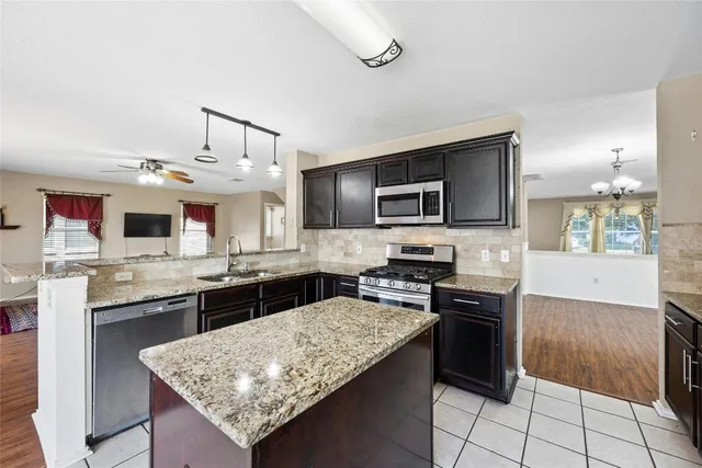 a kitchen with stainless steel appliances granite countertop a sink stove and refrigerator