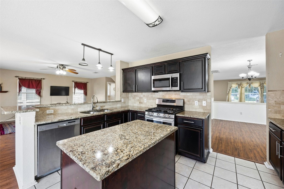 3618 Windhill Loop Round Rock, TX 78681 - Photo 7 of 30 a kitchen with stainless steel appliances granite countertop a sink stove and refrigerator