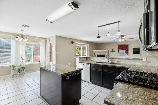 a kitchen with stainless steel appliances granite countertop a sink stove and cabinets