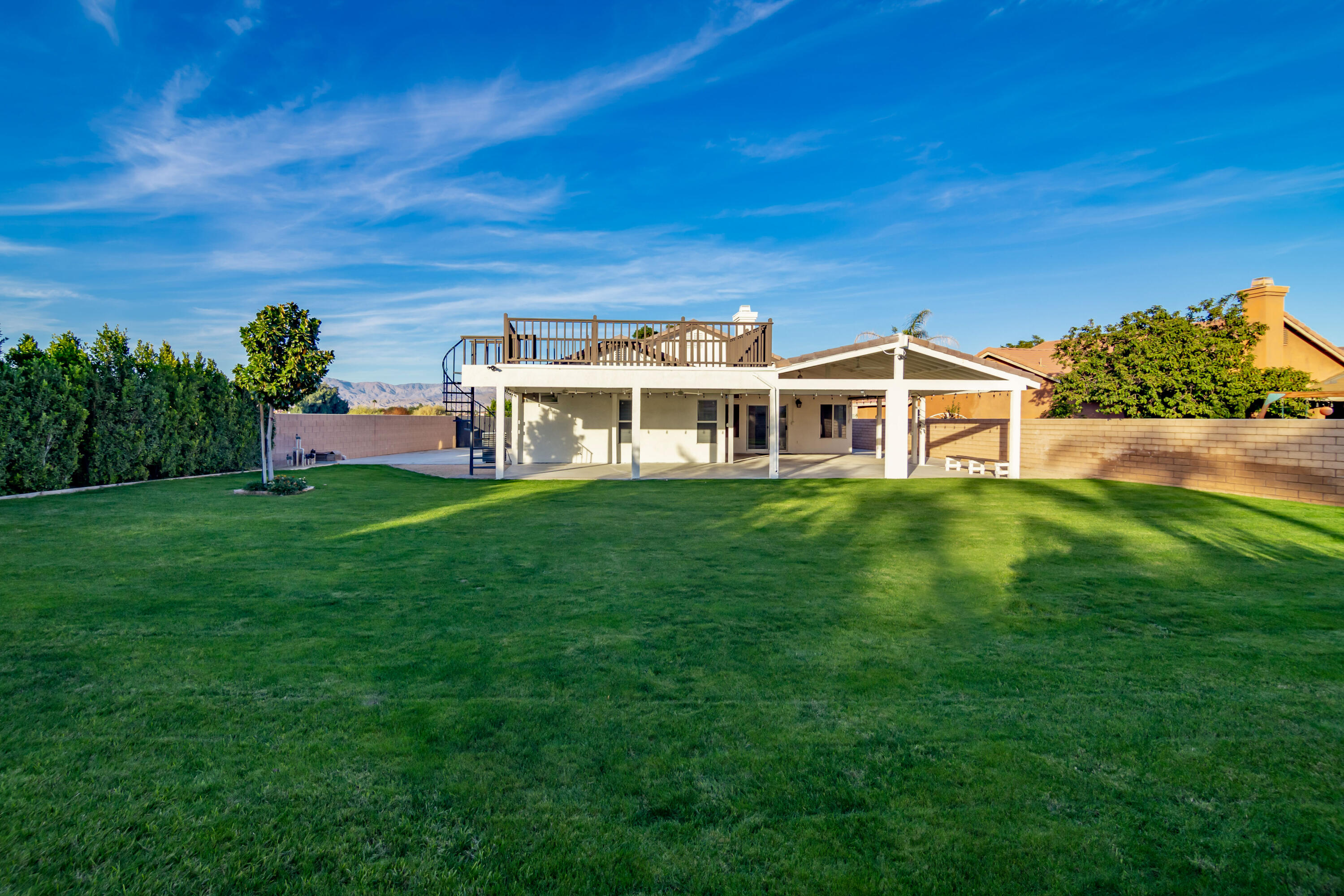 80265 Moonshadow Drive Indio, CA 92201 - Photo 12 of 32 a view of a house with a big yard potted plants and large tree
