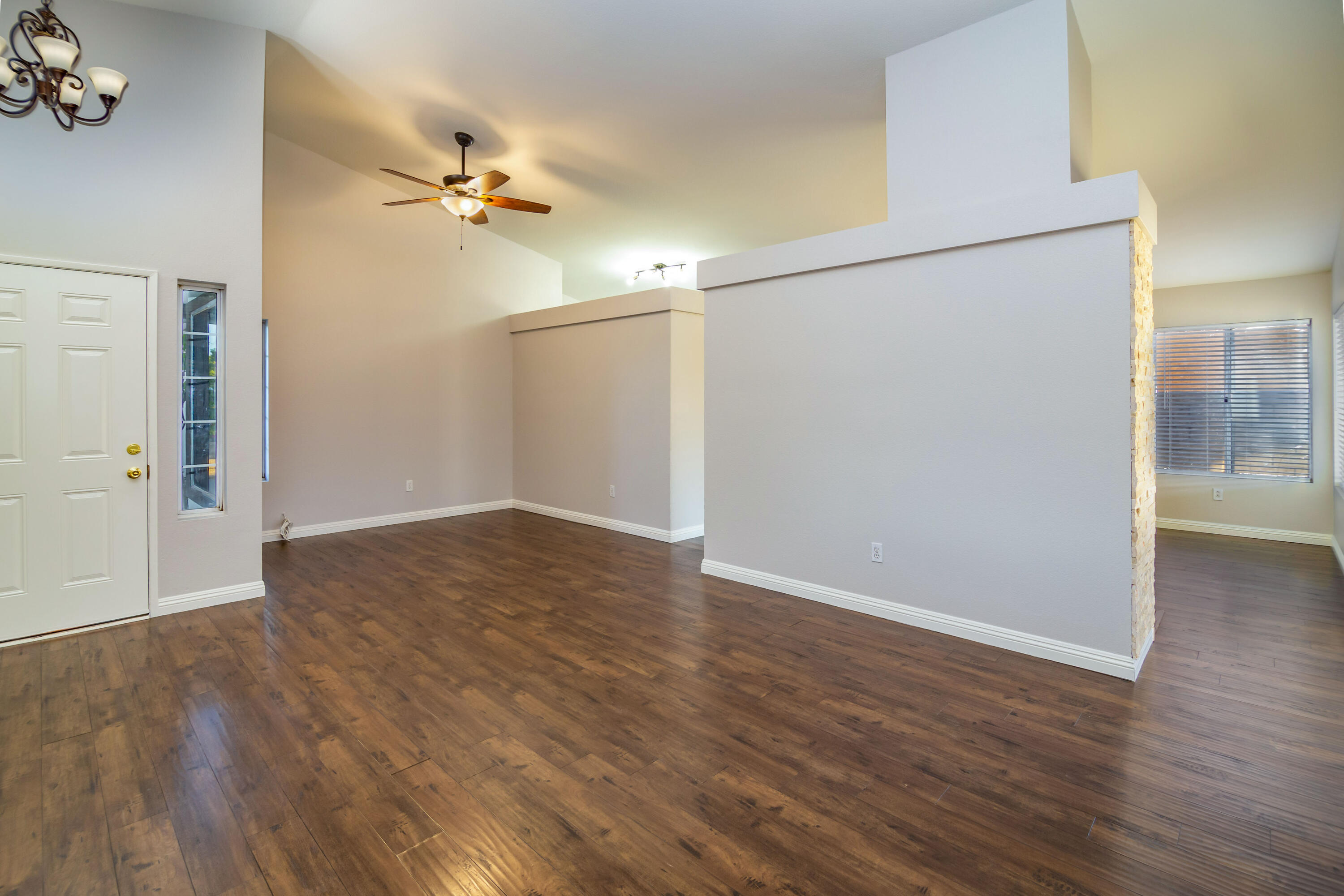 80265 Moonshadow Drive Indio, CA 92201 - Photo 18 of 32 an empty room with wooden floor chandelier fan and windows